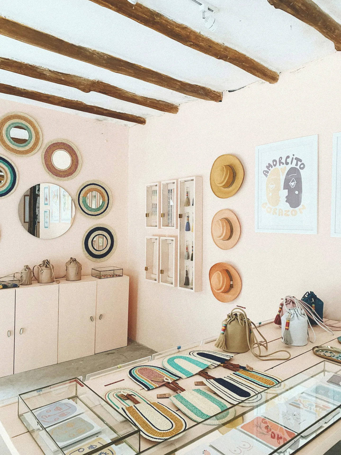 wide shot of a boutique with itens hanging on the wall such as hats